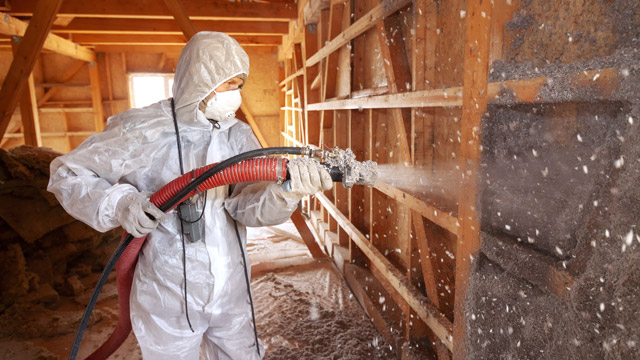 man spraying insulation
