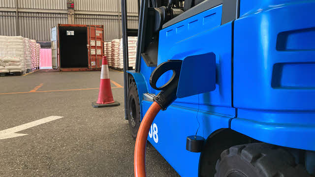 An electric forklift charging in a commercial building