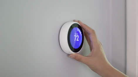 A person configuring an integrated control thermostat
