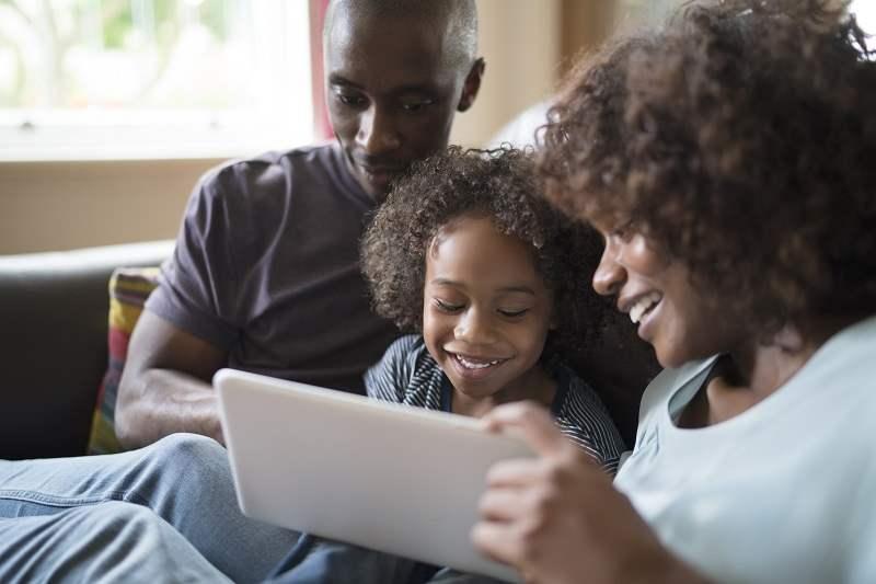Uma família de Massachusetts a utilizar um tablet para encontrar programas de eficiência energética